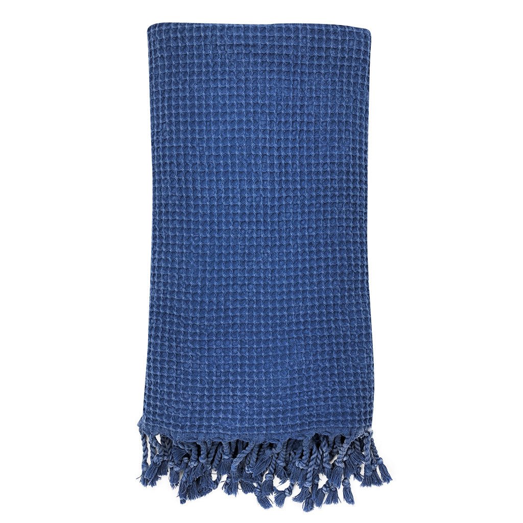 Blue textured towel with frayed edges on a white background