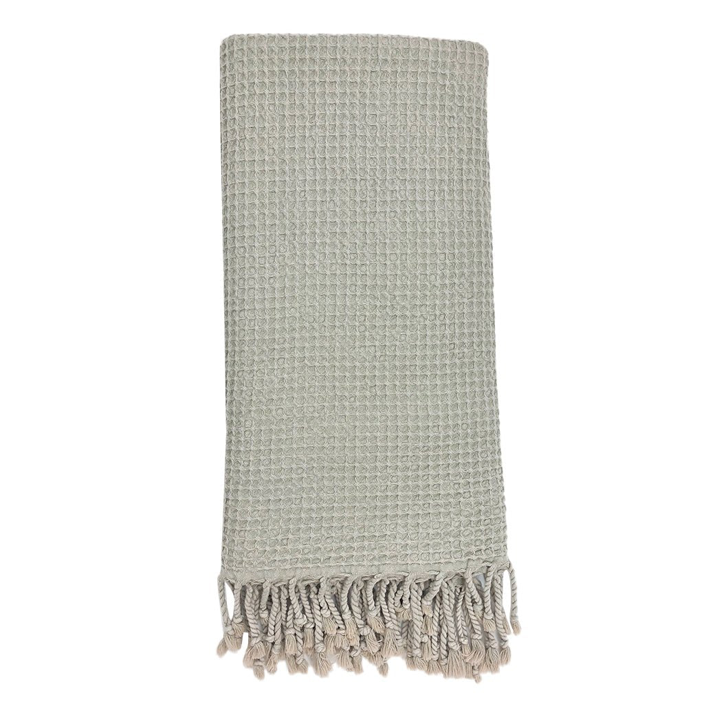 Textured throw blanket with fringes on a white background